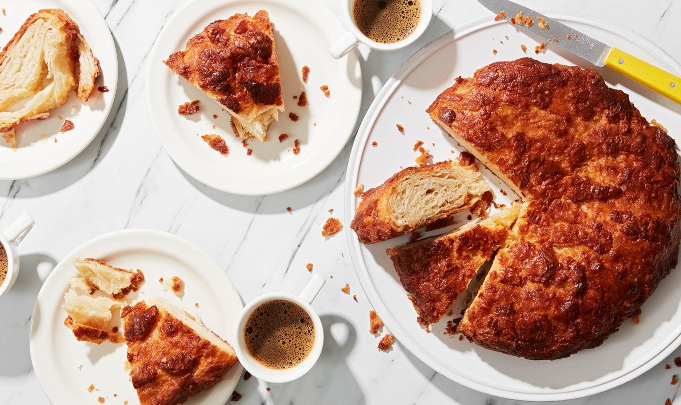 A classic butter Breton cake, Kouign-Amann with a few slices removed on plates